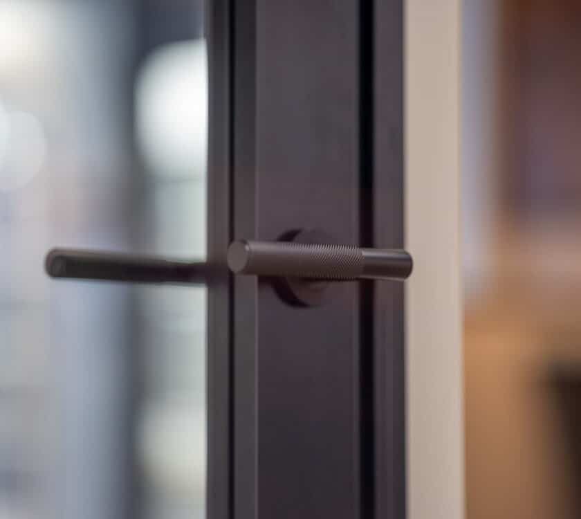 close up of Aluco steel-look door showing centrally located glass. 