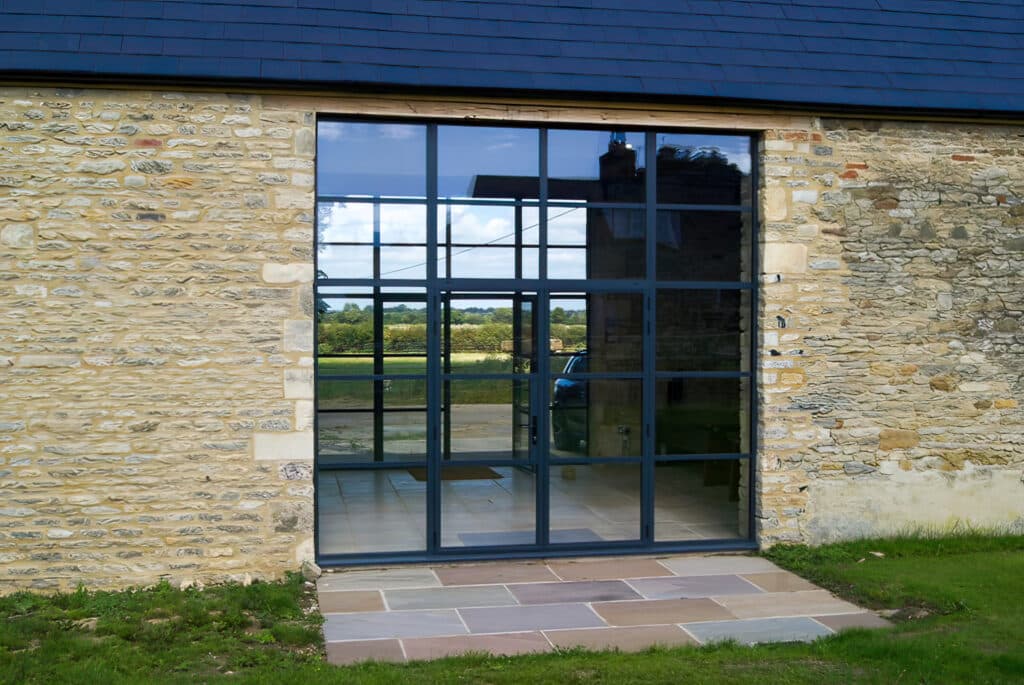 glazed industrial style french doors in a stone barn