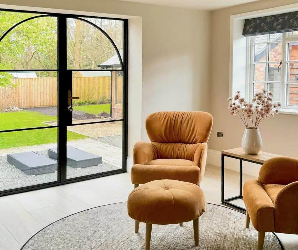 black heritage french doors in a stylish lounge with armchairs