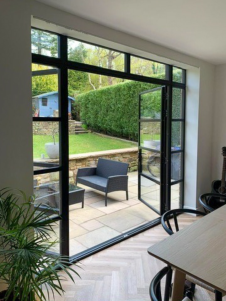 steel look french doors in cheshire house, open leading to modern patio area