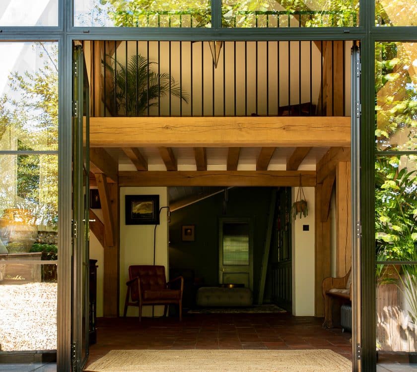 black French doors with sidelights creating an entrance screen in an oak-framed hallway