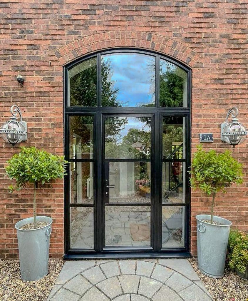 curved steel look entrance door in a brick barn-style building