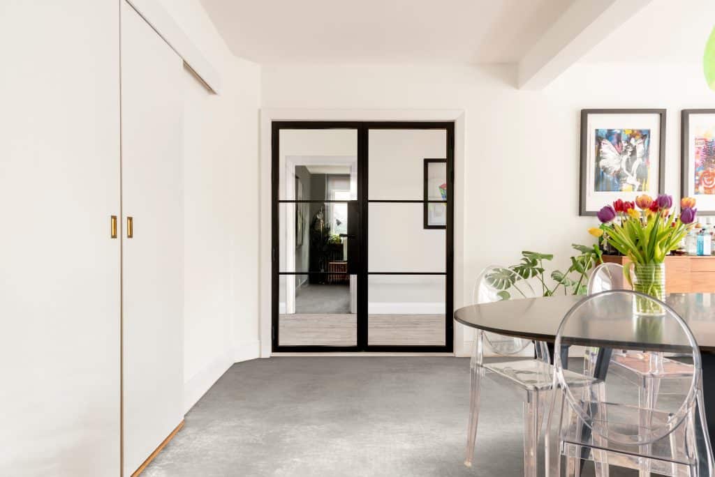 Black Aluco heritage doors in a stylish dining room with wood floor