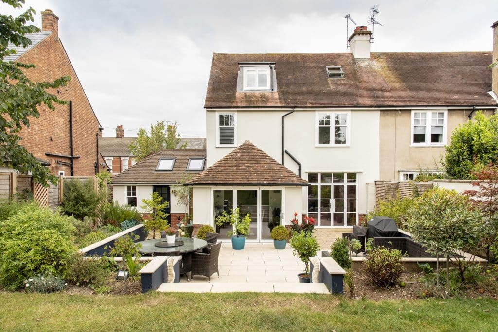 Back of a period home featuring white steel look doors with side panels