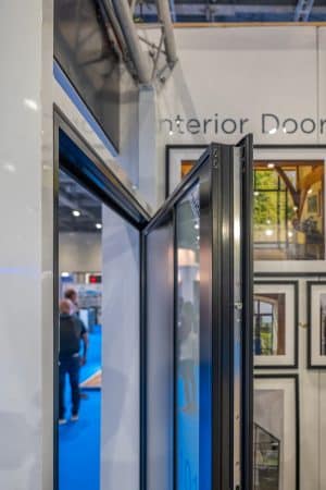 partially open aluco front door with pictures behind in an exhibition stand