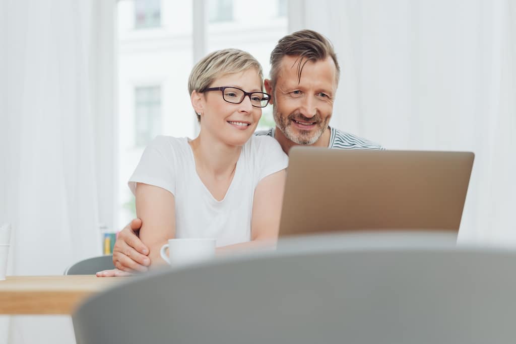happy couple looking at a laptop with door quotation