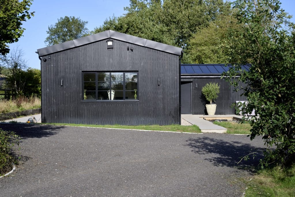 heritage windows and doors in devon barn conversion showing black cedar cladding lawn and aluco windows